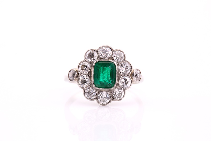 An Edwardian emerald and diamond cluster ring