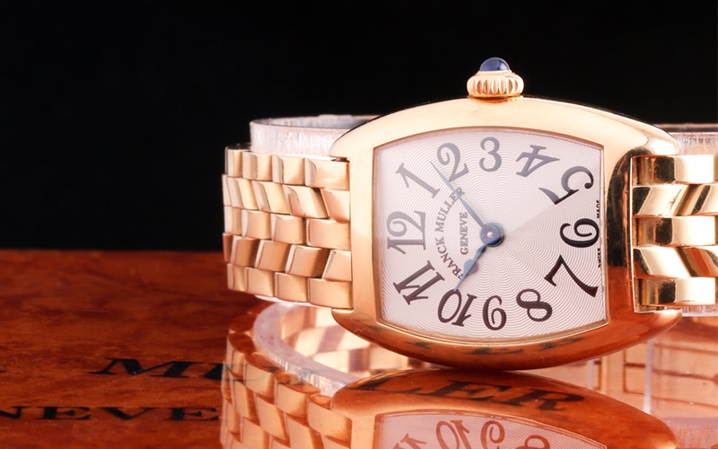 Franck Muller gold watch sideways up on table