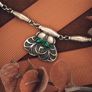A Georg Jensen fringe necklace set with amethyst, with five foliate pendants with patinated ground collet set with oval amethyst cabochons