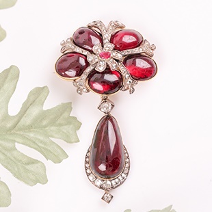 A late Georgian early Victorian pendant, set with a large cabochon garnet within a border of old-cut diamonds