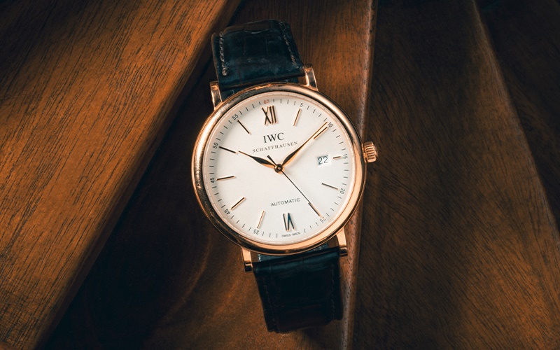 IWC gold watch with black leather strap