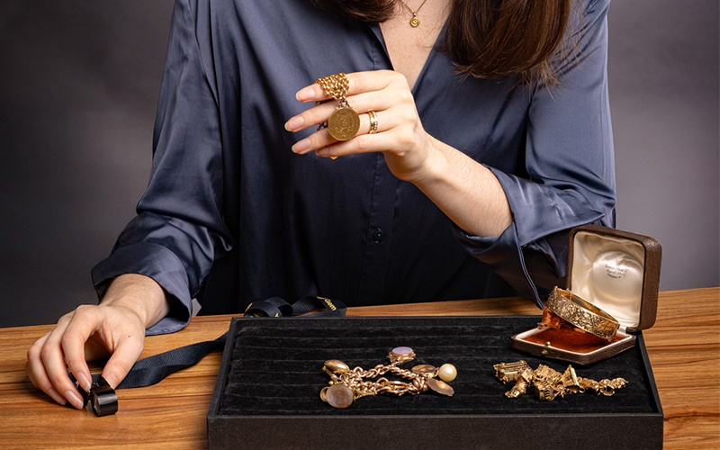Niamh Thomas appraising a collection of gold jewellery