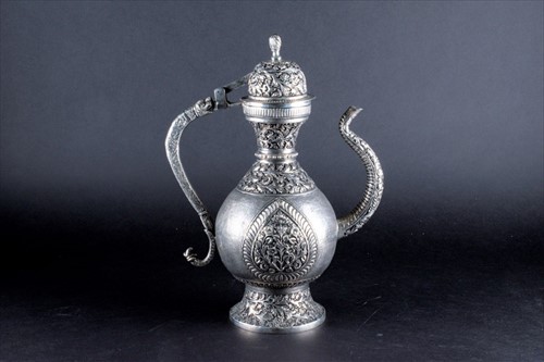 Lot 159 - An Indian white metal jug with hinged lid,...