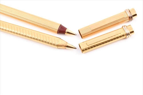 Lot 226 - Cartier. Two similar gold plated pens both...