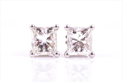 Lot 639 - A pair of diamond stud earrings each claw-set...