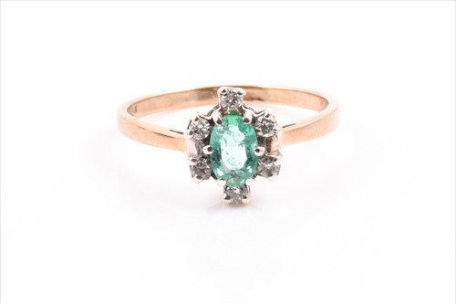 Lot 504 - A 9ct yellow gold, diamond, and emerald ring...