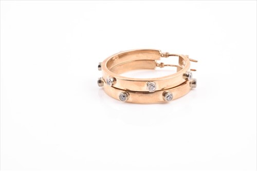 Lot 592 - A pair of 9ct yellow gold and diamond hoop...