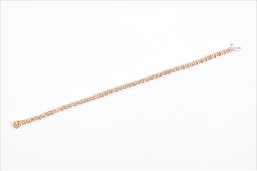 Lot 524 - A yellow metal and diamond line bracelet with...