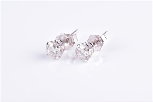 Lot 621 - A pair of solitaire diamond ear studs set with...