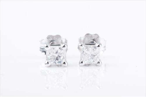 Lot 462 - A pair of solitaire diamond ear studs each set...