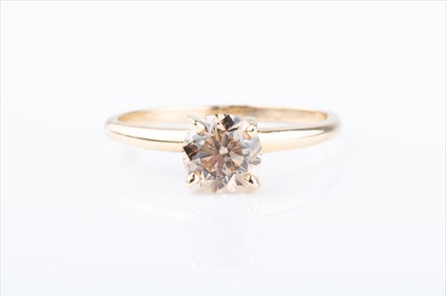 Lot 455 - A solitaire diamond ring set with a cinnamon...