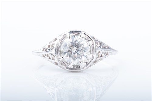 Lot 442 - A solitaire diamond ring set with a round...