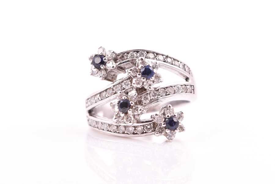 Lot 693 - A diamond and sapphire floral cluster...