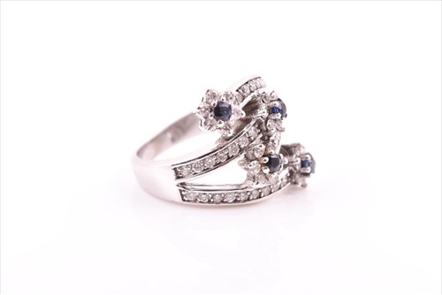 Lot 693 - A diamond and sapphire floral cluster...