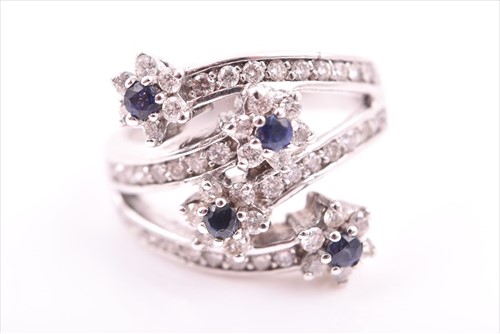 Lot 693 - A diamond and sapphire floral cluster...