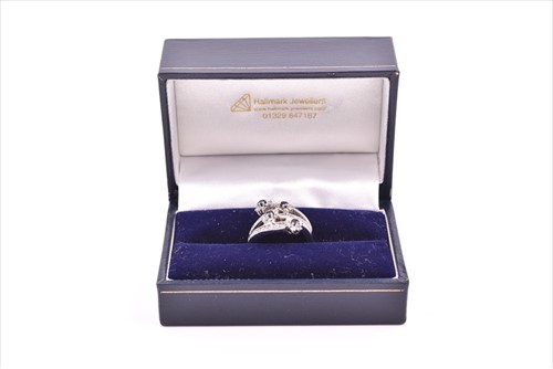 Lot 693 - A diamond and sapphire floral cluster...