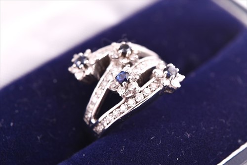 Lot 693 - A diamond and sapphire floral cluster...