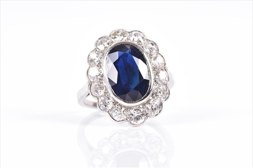 Lot 586 - A diamond and sapphire cocktail ring of oval...