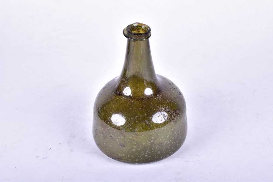 Lot 180 - A late 17th or early 18th century green glass...