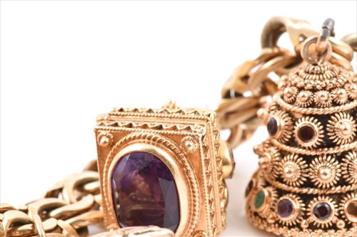 Lot 657 - An unusual yellow metal charm bracelet of...