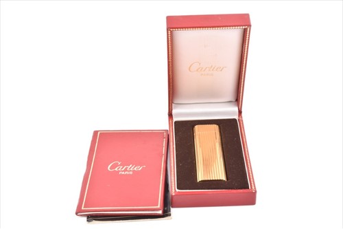 Lot 240 - A Cartier Paris gold-plated cigarette lighter...