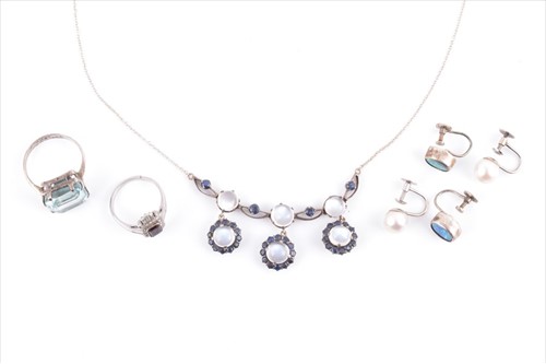 Lot 519 - A silver, moonstone, and sapphire drop pendant...