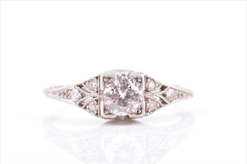 Lot 516 - An Art Deco platinum and diamond ring centred...