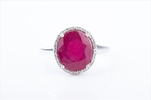 Lot 410 - A diamond and ruby cluster ring set with a...