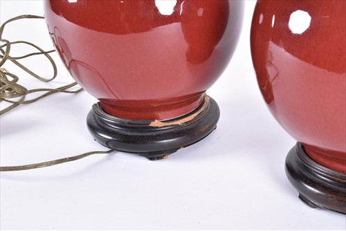 Lot 179 - A pair of Chinese sang de boeuf ceramic lamps...