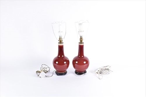 Lot 179 - A pair of Chinese sang de boeuf ceramic lamps...