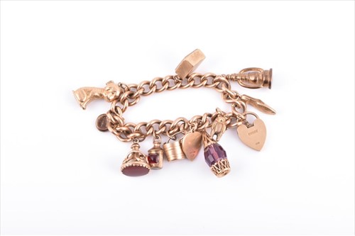 Lot 726 - A 9ct yellow gold curb-link charm bracelet...