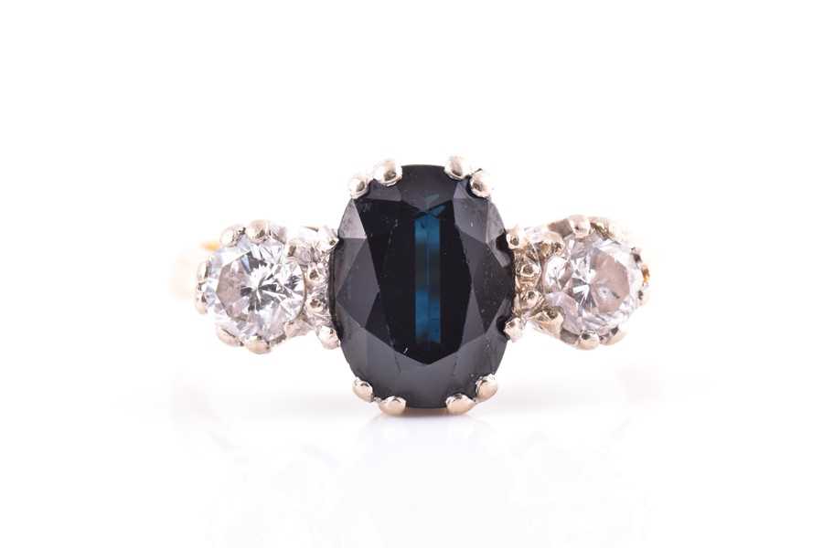 Lot 561 - A diamond and sapphire three stone ring...