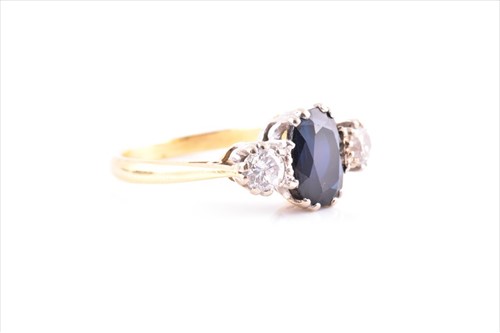 Lot 561 - A diamond and sapphire three stone ring...