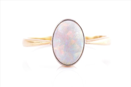 Lot 562 - An 18ct yellow gold and opal ring set with a...