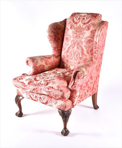 Lot 85 - An English upholstered wingback armchair with...