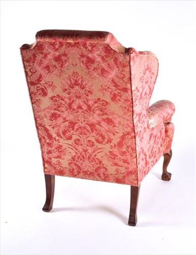 Lot 85 - An English upholstered wingback armchair with...