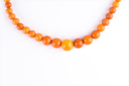 Lot 518 - An amber beaded necklace approx 60 cm long,...