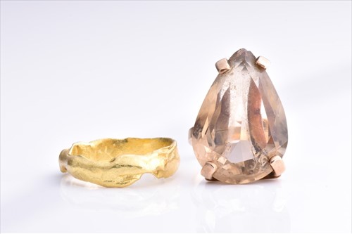 Lot 522 - A yellow metal and smokey quartz ring set with...