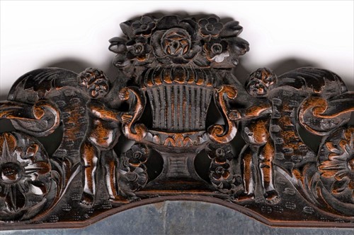 Lot 123 - A 19th century oak carved mirror with figural...