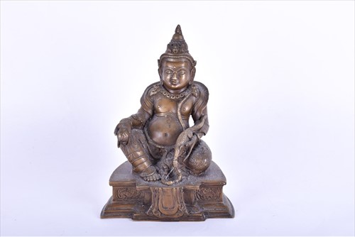 Lot 255 - A Tibetan bronze model of a guardian deity...