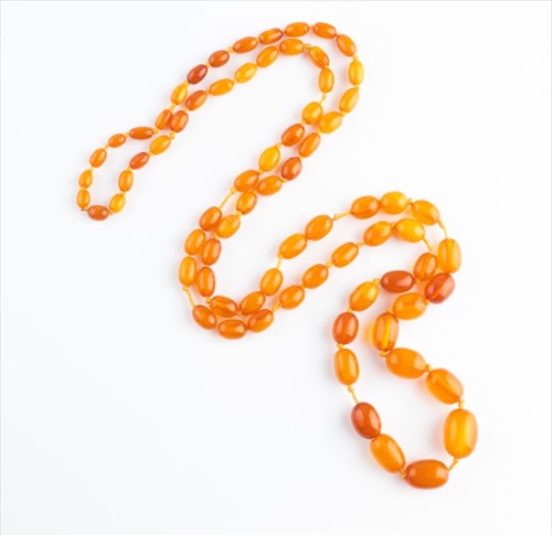 Lot 475 - An opera length amber beaded necklace...