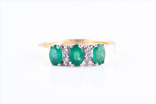 Lot 477 - A yellow metal, diamond and emerald ring set...