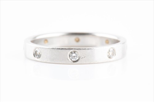 Lot 518 - A platinum and diamond eternity ring inset...