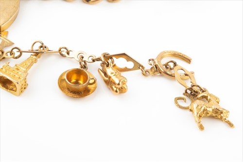 Lot 427 - A 9 carat gold charm bracelet suspended with...