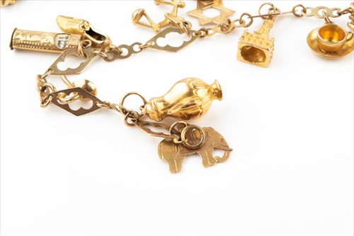 Lot 427 - A 9 carat gold charm bracelet suspended with...