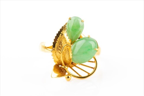 Lot 521 - A yellow metal and jade ring of foliate design,...