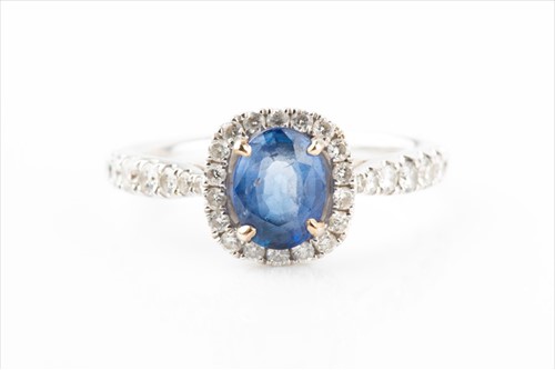 Lot 485 - A diamond and sapphire cluster ring set with a...