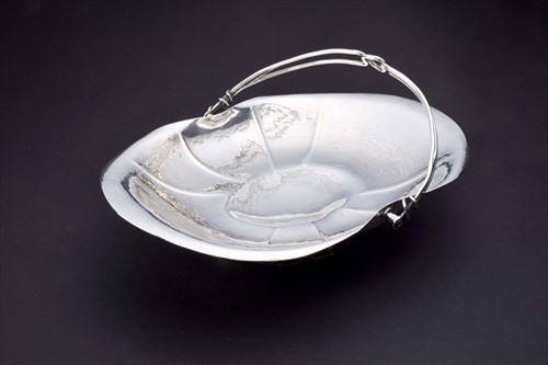 Lot 409 - An Arts and Crafts silver swing handle basket...