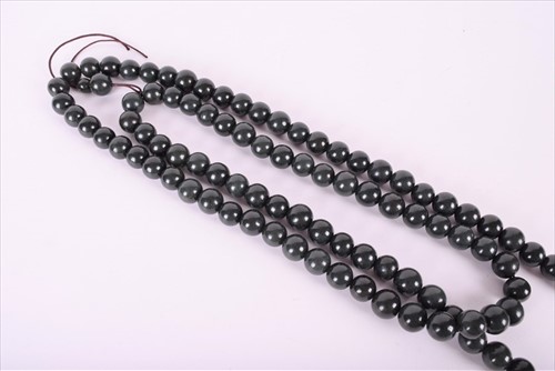 Lot 476 - A Chinese dark green jade bead necklace strung...