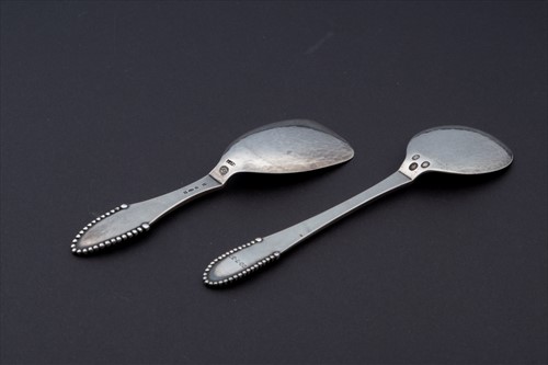 Lot 317 - Two Georg Jensen 'Beaded' whole metal spoons...